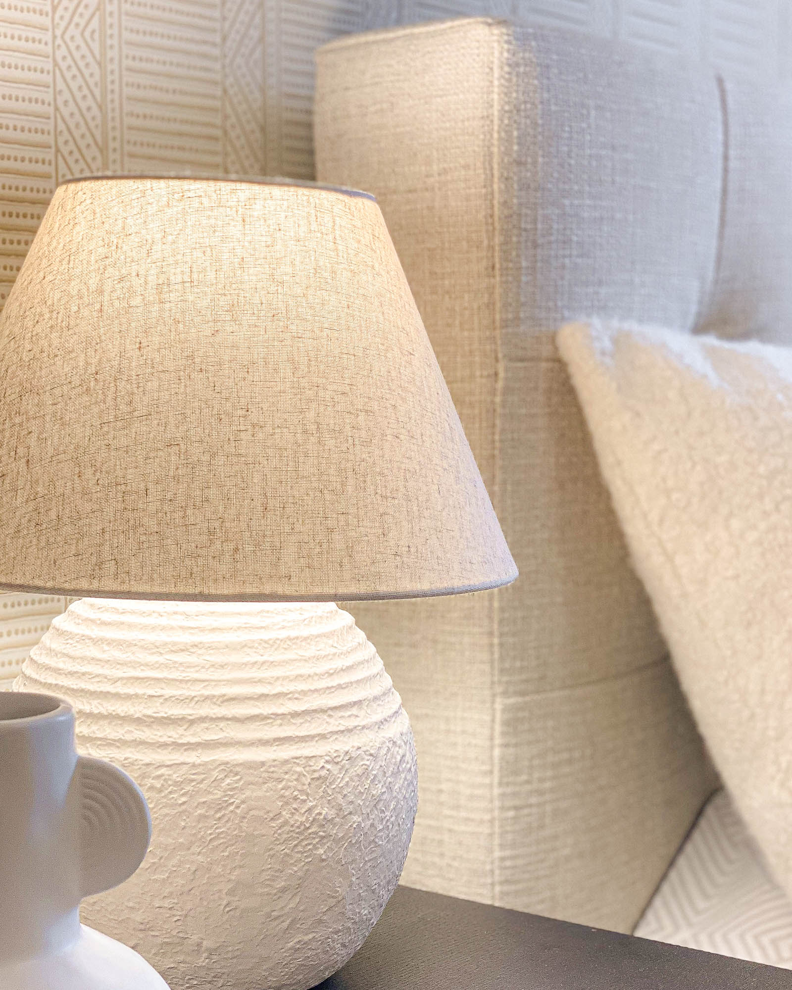 Lampa nona z lnianym abażurem i ceramiczną chropowatą podstawą w projekcie sypialni w Warszawie